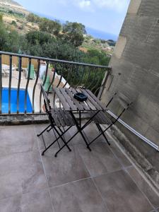 una sedia sul balcone con vista sulla piscina di Il figolla b&b a Xagħra
