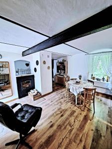 a living room with a table and chairs and a fireplace at Zielona Samotnia in Czaplinek +42 photos