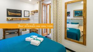 ein Schlafzimmer mit einem blauen Bett und einem Spiegel in der Unterkunft Ventu de Ma in Vernazza
