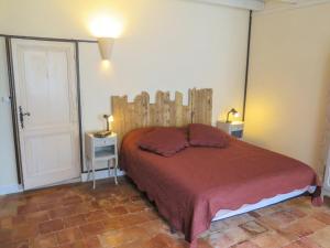 een slaapkamer met een groot bed met een houten hoofdeinde bij Holiday Home La Raze by Interhome in Bonneville-et-Saint-Avit-de-Fumadières
