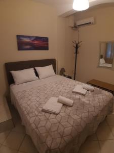 a bedroom with a large bed with towels on it at Central AXD in Alexandroupoli