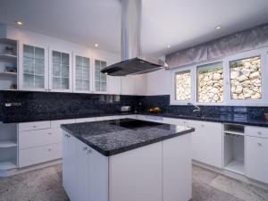 een keuken met witte kasten en een zwart aanrechtblad bij Holiday Home Finca Edel by Interhome in Moraira +46 foto's