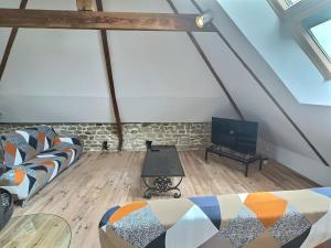 a living room with a couch and a tv at Villa ocean in Loctudy