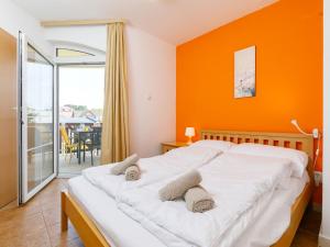 バラトンレッレにあるApartment Charlie by Interhomeのベッドルーム1室(オレンジ色の壁の大型ベッド1台付)