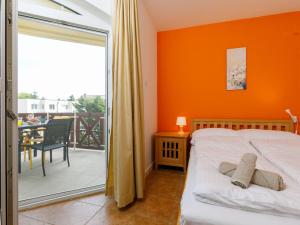 バラトンレッレにあるApartment Charlie by Interhomeのオレンジ色の壁のベッドルーム、ベッド、バルコニーが備わります。 +26枚の写真