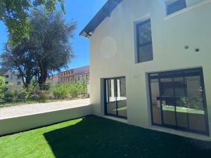 a white house with a yard with green grass at Elégante maison de ville rénovée in Toulouse
