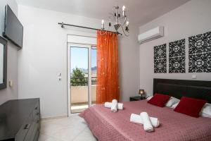 a bedroom with a bed with red and white towels on it at Al Mare Apartments in Afantou