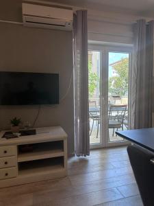 a living room with a television and a sliding glass door at Apartment Antea in Šibenik