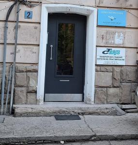 czarne drzwi na kamiennym budynku z znakiem w obiekcie Apartment Airport Sofia w mieście Sofia