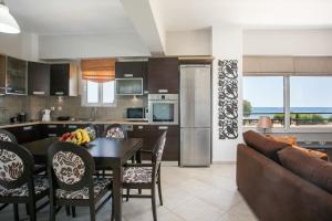 a kitchen and living room with a table and chairs at Al Mare Apartments in Afantou