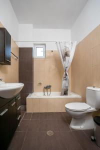 uma casa de banho com uma banheira, um WC e um lavatório. em Al Mare Apartments em Afantou