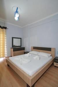 um quarto com uma cama grande e uma televisão em “apHEARTment Gjirokastra” em Gjirokastër