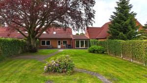 a house with a yard with a hedge at Ferienhaus Nannen in Rechtsupweg