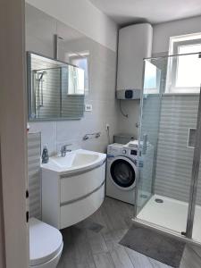 a bathroom with a sink and a washing machine at Apartment Antea in Šibenik