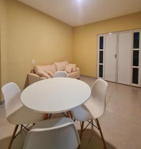 een witte tafel en stoelen in een kamer met een bank bij Apartamento Praia do Prea in Jericoacoara +31 foto's