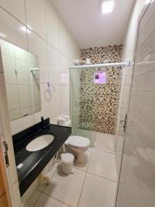 een badkamer met een wastafel, een toilet en een douche bij Apartamento Praia do Prea in Jericoacoara