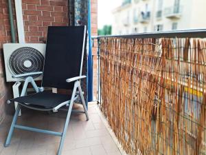 a black chair sitting on a balcony with a fan at Jaky Maison Torino, Cozy & Modern Stay in Turin +35 photos