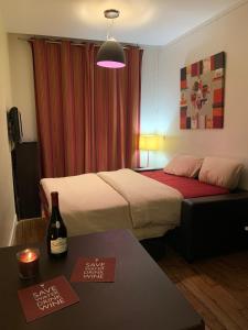 Camera con letto e tavolo con bottiglia di vino di Appartement Marais Cœur Historique a Parigi