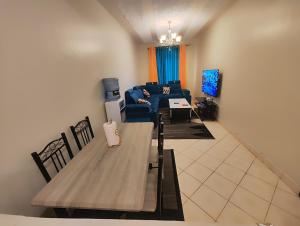 ein Wohnzimmer mit einem Tisch und einem Sofa in der Unterkunft Romantic 1Bedroom Gateway in Kinoo in Kikuyu