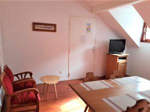un soggiorno con un tavolo e una TV di Appartement Confort 2 Pièces à Vignec avec Piscine et Proche Saint-Lary-Soulan - FR-1-504-424 a Vignec
