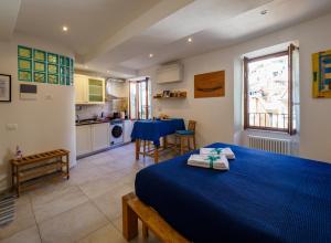 1 Schlafzimmer mit einem blauen Bett und einer Küche in der Unterkunft Ventu de Ma in Vernazza