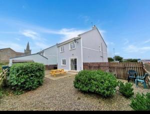 a white house with a wooden fence in front of it at Sunset view Homestay in Milltown Malbay