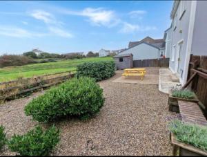 a patio with a bench and a picnic table at Sunset view Homestay in Milltown Malbay