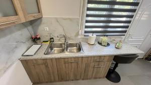 a kitchen counter with a sink and a window at Casa di Giovanna in Volos