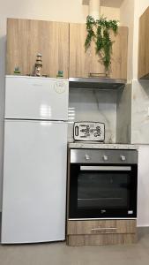 a kitchen with a stove and a white refrigerator at Casa di Giovanna in Volos +17 photos
