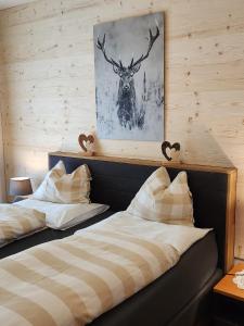 a bedroom with two beds and a picture of a deer at Haus Martina in Sand in Taufers