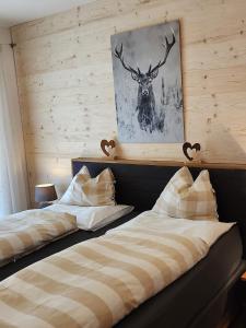 2 camas en una habitación con una foto de un ciervo en Haus Martina en Sand in Taufers