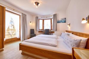 um quarto com uma cama grande e uma janela em Hotel Antonia em Oberammergau