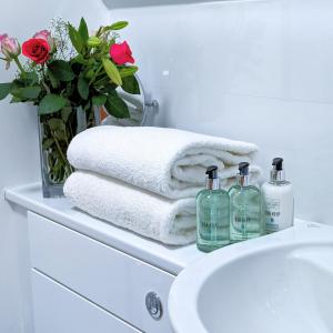 ein Waschbecken mit Handtüchern und eine Vase Blumen in der Unterkunft Ben Cruachan Inn in Loch Awe