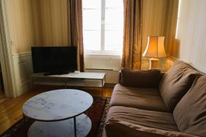 un soggiorno con divano, tavolo e TV di Brodderud Apartments a Mariestad