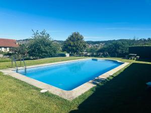 uma grande piscina num quintal com relva em Casa familiar vista Rías em Vigo