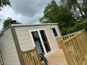 a tiny house with two chairs on a deck at Camping L'Orée des Caps in Licques