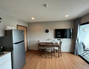 Una cocina y un comedor con una mesa y un refrigerador. en Title Rent Rawai, en Rawai Beach