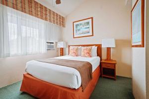 Habitación de hotel con cama grande y ventana en Banyan Harbor Resort, en Lihue