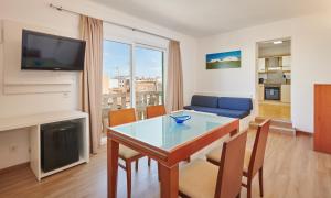 salon ze stołem i niebieską kanapą w obiekcie Hotel Colonial w miejscowości Colonia Sant Jordi