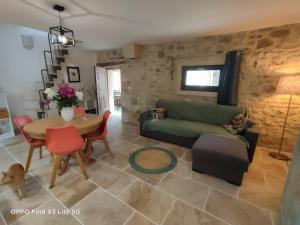 a living room with a green couch and a table at Gite à la ferme in Ongles