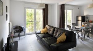 a living room with a black couch and a table at Appart Hotel Corte HR in Corte