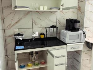 uma cozinha com um lavatório e um micro-ondas em Apart. Bela Vista em Porto Ferreira