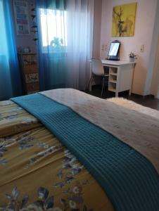 Schlafzimmer mit einem Bett, einem Schreibtisch und einem Laptop in der Unterkunft Kim`s Cottage in Görwihl