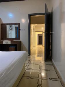 1 dormitorio con cama blanca y pasillo en كيان ألين en Abha