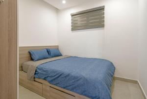 - une petite chambre avec un lit et une couverture bleue dans l'établissement Mường Thanh Apartment SeaView - Căn Hộ Mường Thanh Đà Nẵng, à Đà Nẵng