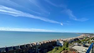 vistas a una playa con edificios y al océano en Seascape - 2 bedroom flat with panoramic sea views, en Hollington