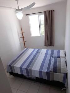 a blue and white bed in a room with a window at Ótimo apartamento, bem localizado in Aracaju