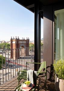 een balkon met een tafel en stoelen en uitzicht op het Colosseum bij Archie Living in Barcelona