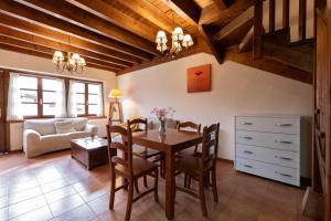 ein Wohnzimmer mit einem Tisch, Stühlen und einem Sofa in der Unterkunft Apartamentos Rurales San Feliz in Pola de Lena
