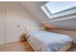 a bedroom with a bed and a skylight at The Heart of Leuven in Leuven